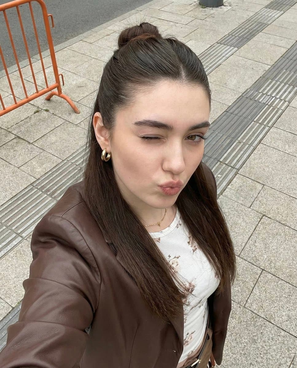 Playful Young Woman Selfie: Brown Jacket & Floral Top - Portrait Photography AI prompt